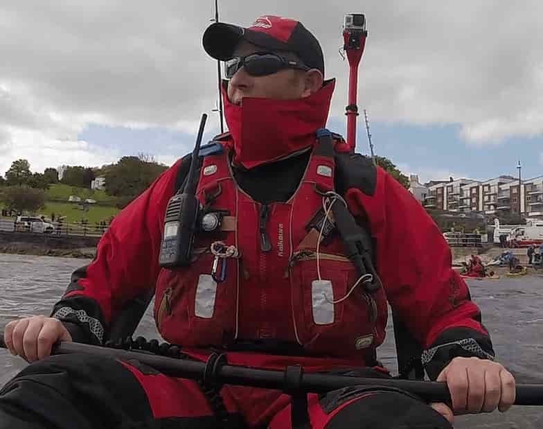 man kayaking with full body wet suit with 2 way radio race safety