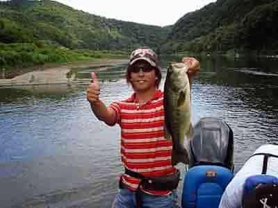 Japan bass fishing man with hat on holding up bass