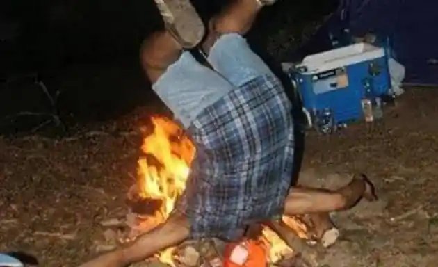man falling into fire head first feet up in the air