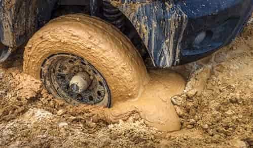 thick mud vehicle in 4 wheel drive spinning and stuck