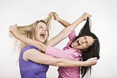 Two women fighting and pulling each others hair and both are screaming