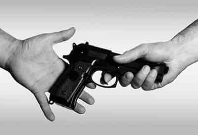 gun confiscated- man handing hand gun to officer after a shooting in self defense