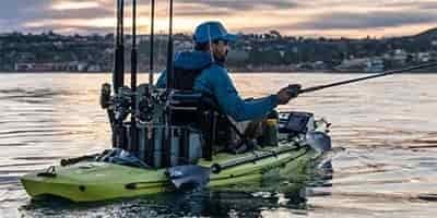 sunrise fishing with man with complete setup for fishing in a kayak