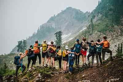 large group of college friends hiking in mountains