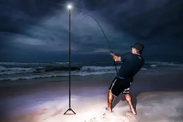 night surf fishing with light on a pedalstal
